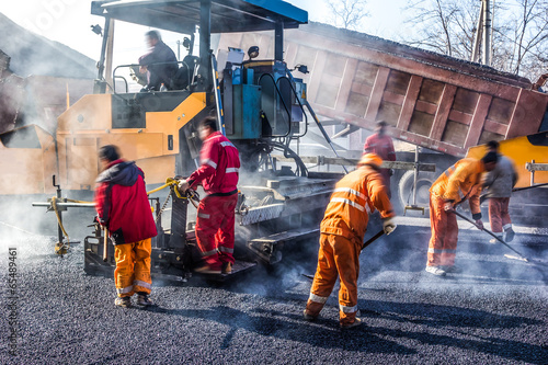 Obraz na płótnie Workers making asphalt with shovels at road constructio