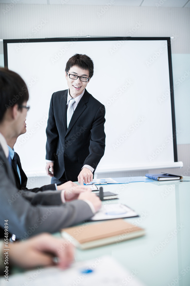 Businessman standing in front of colleagues during a meeting Businessman standing in front of colleagues during a meeting