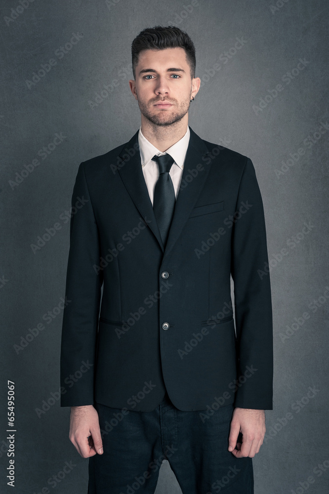 Young businessman portrait against dark grunge background. Young businessman portrait against dark grunge background.