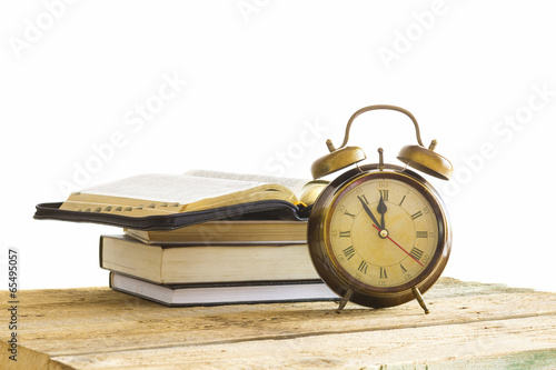 Bible with clock on wood