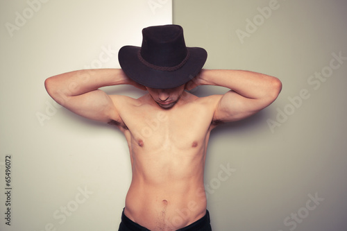 Shirtless young cowboy against dual colored background