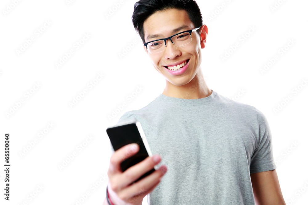 Smiling asian man using smartphone on gray background