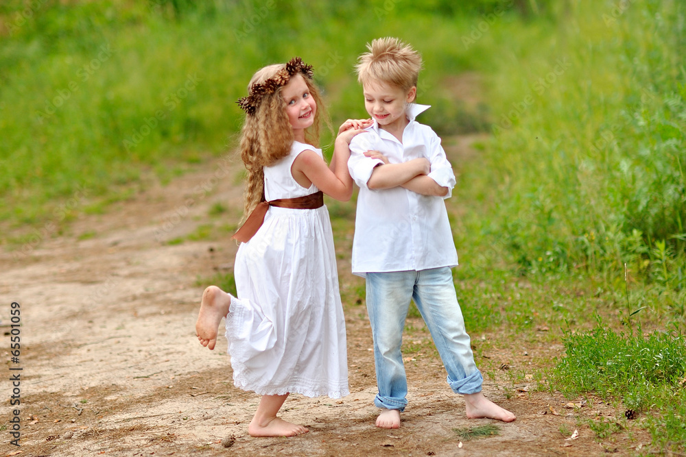 Fototapeta premium Portrait of a boy girl in a summer forest
