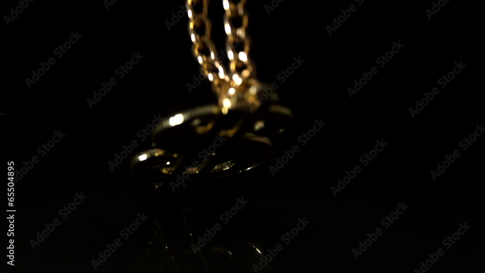 Gold dollar chain falling on black background Gold dollar chain falling on black background