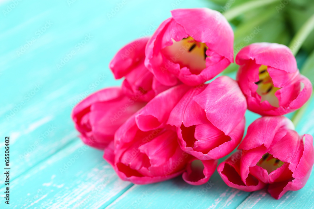 Fototapeta premium Beautiful tulips on color wooden background