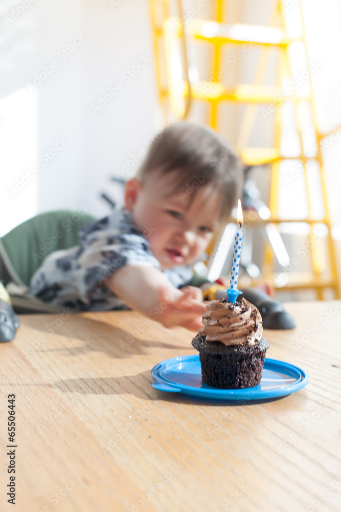 Boy reaching towards a birthday cake Boy reaching towards a birthday cake