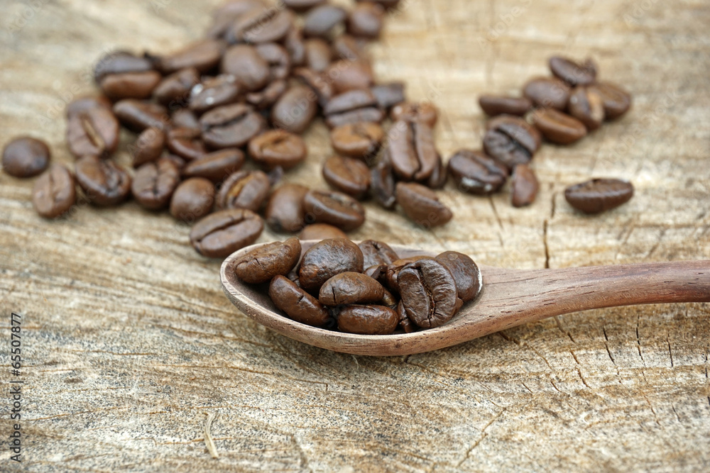 Fototapeta premium Coffee beans on an old wooden background