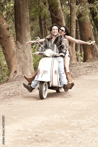 young attractive couple traveling together by scooter
