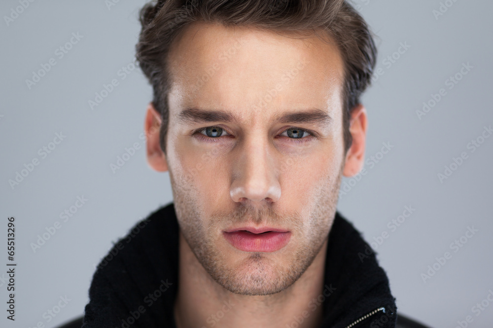 Fashion man face close up over gray background Fashion man face close up over gray background