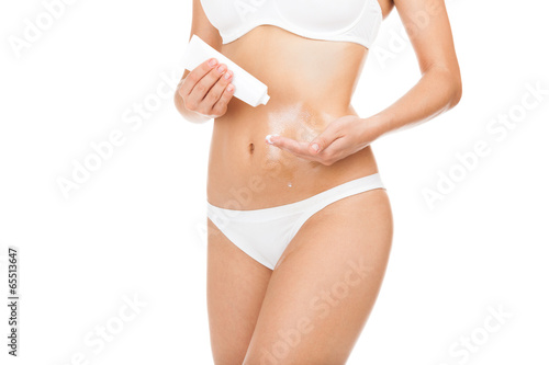 Woman applying moisturizer cream lotion on belly