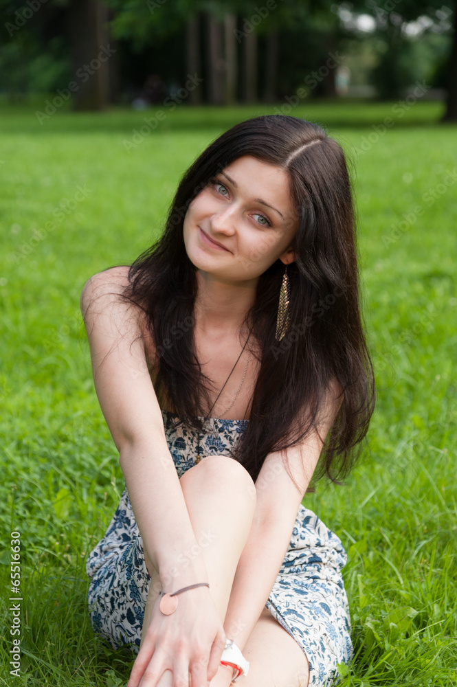 Happy girl relaxing on grass field in park Happy girl relaxing on grass field in park