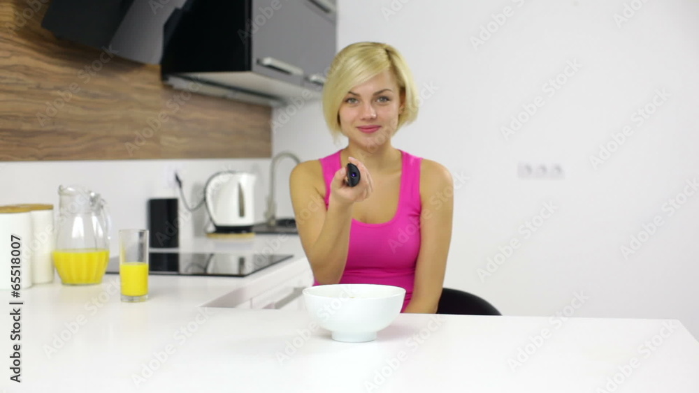 woman watching tv remote control eat corn flakes woman watching tv remote control eat corn flakes