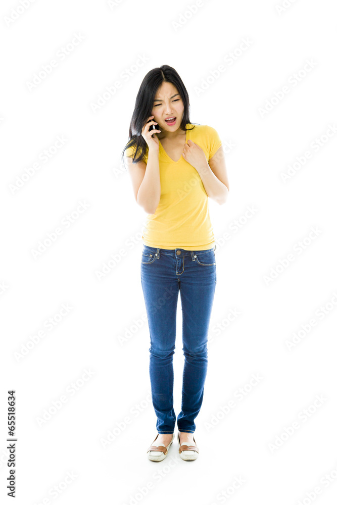 Young Asian woman talking on a mobile phone and looking Young Asian woman talking on a mobile phone and looking