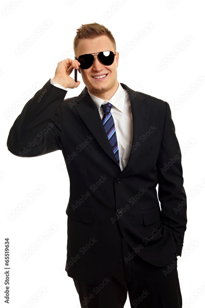 Man in suit and sunglasses talks into mobile phone Man in suit and sunglasses talks into mobile phone