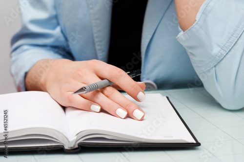 Business woman writing in notebook