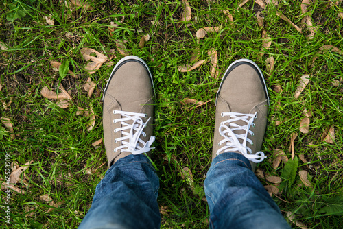 Man in gum shoes standing on the green grass