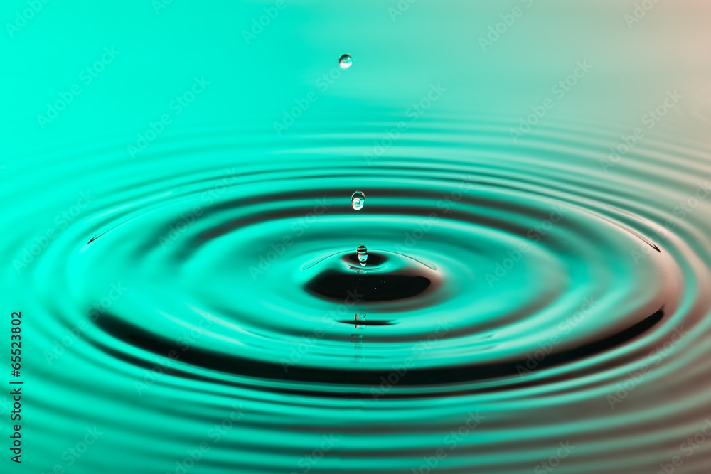 Water drop close up with concentric ripples colourful amberblue Water drop close up with concentric ripples colourful amberblue