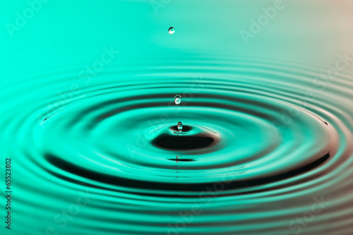 Water drop close up with concentric ripples colourful amberblue