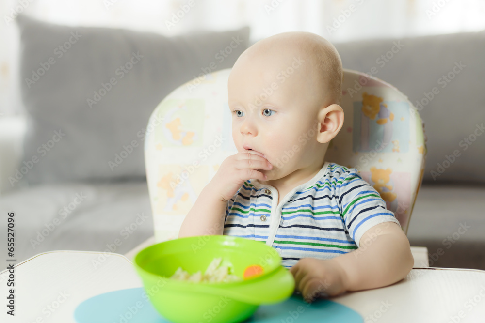 6 months baby is eating pasta for dinner with his hands 6 months baby is eating pasta for dinner with his hands