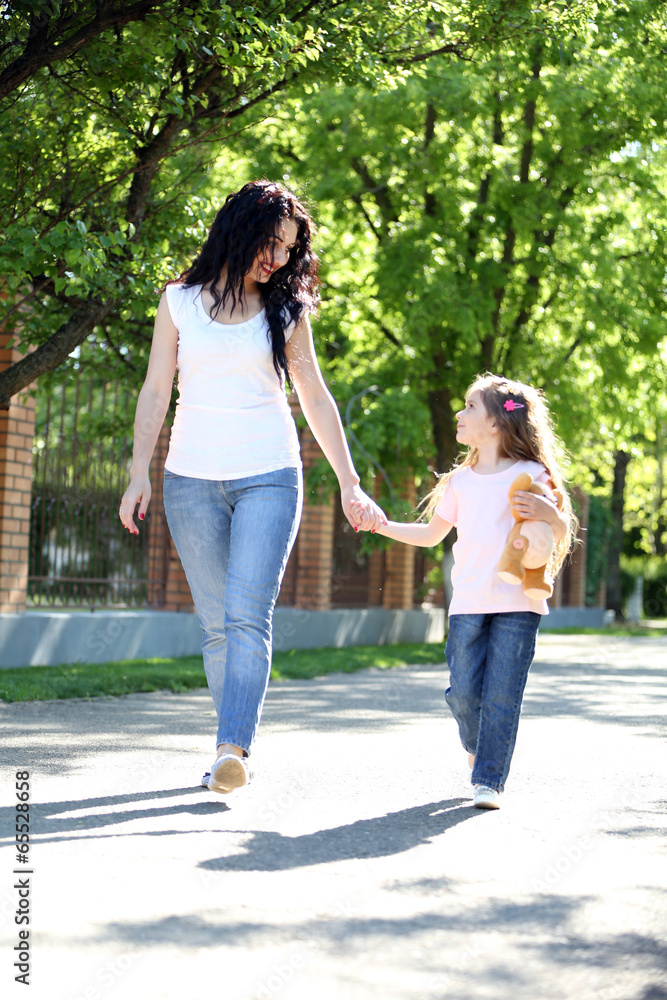 Happy mom and daughter. Walk in the green park Happy mom and daughter. Walk in the green park