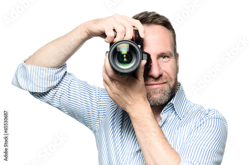 Männlicher Fotograf fokussiert und nimmt ein Bild auf photo