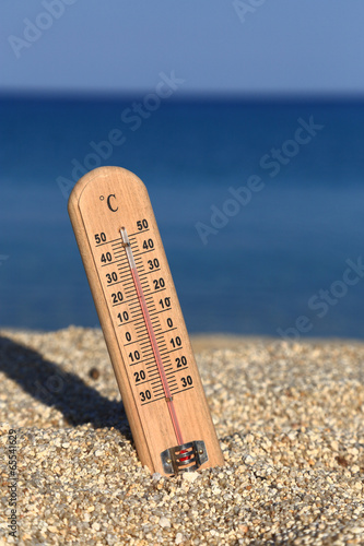 Thermometer on a beach shows high temperatures