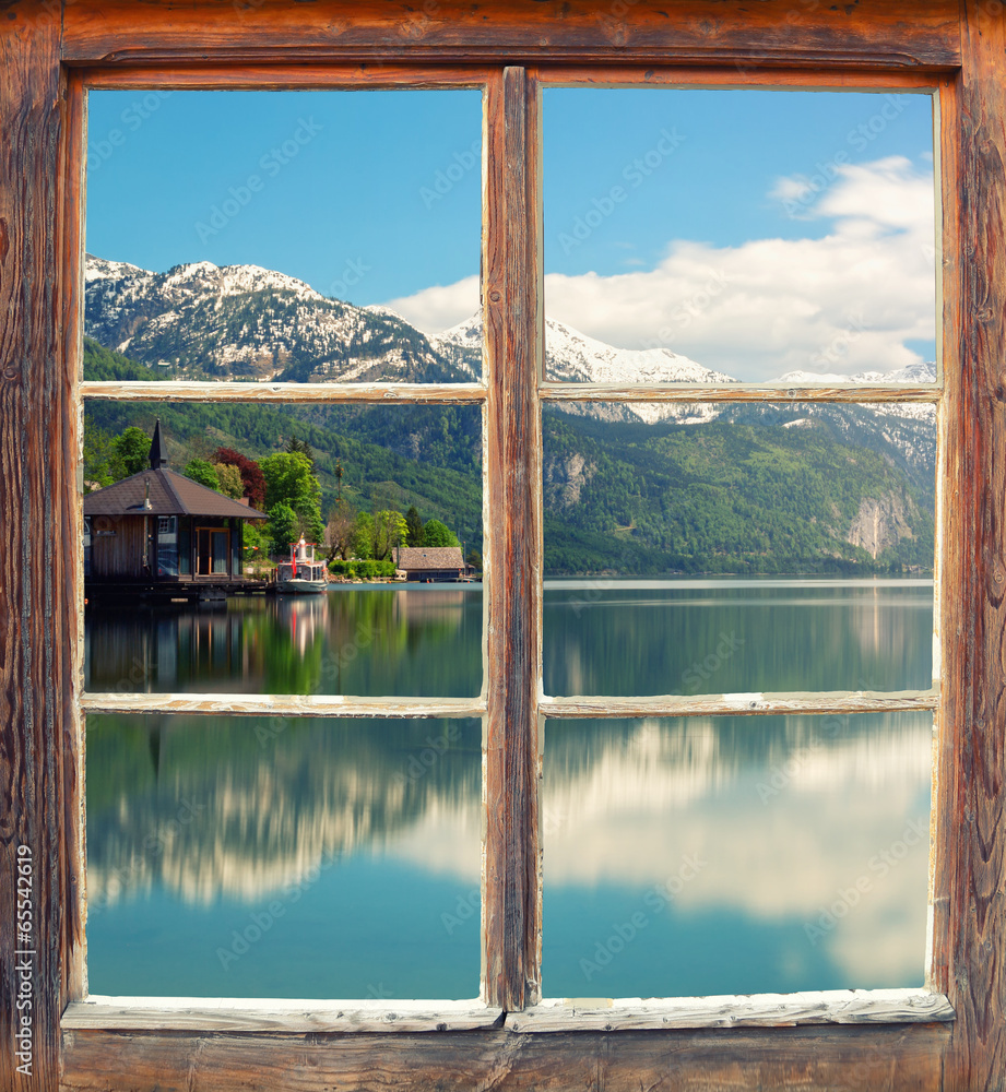 Fototapeta Zamknięte drewniane okno z widokiem na jezioro, góry i domki