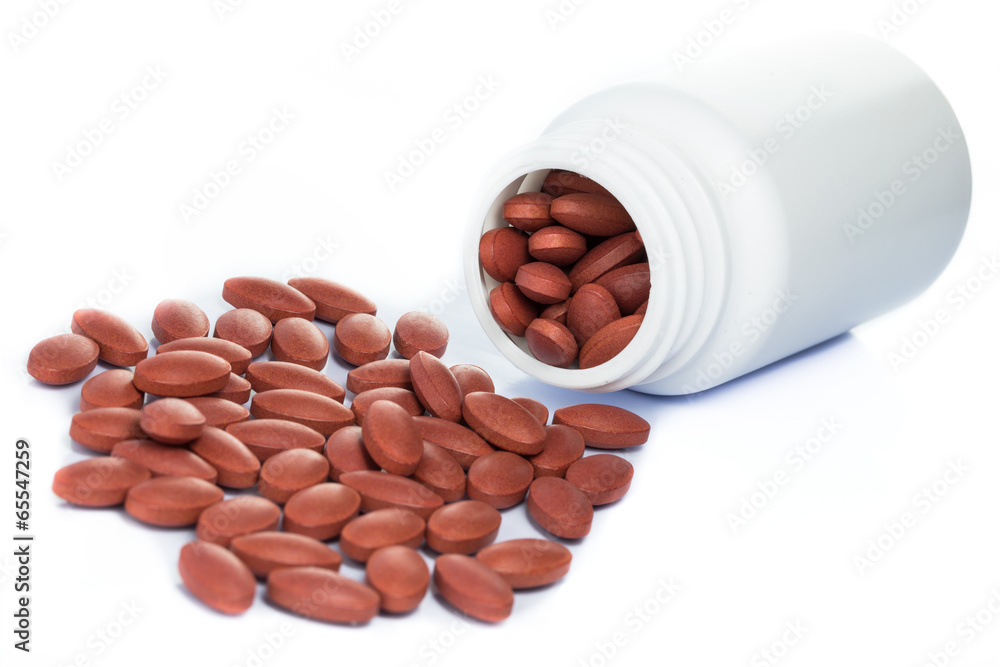 Red pills spilling out of a medicine bottle Red pills spilling out of a medicine bottle