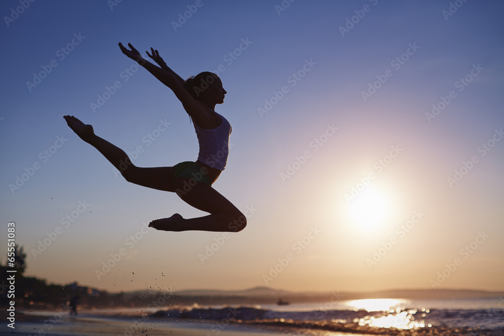 Girl jumping at sunrise or sunset