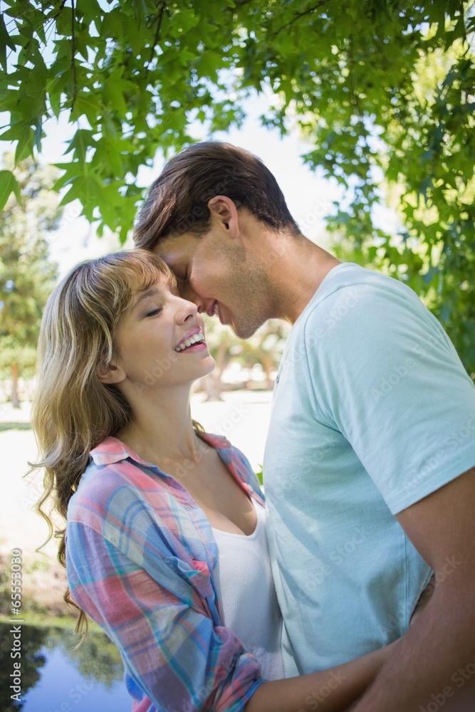 Cute couple smiling and hugging in the park Cute couple smiling and hugging in the park