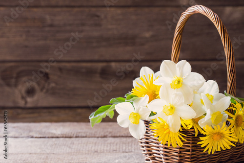 flowers in basket on wooden background