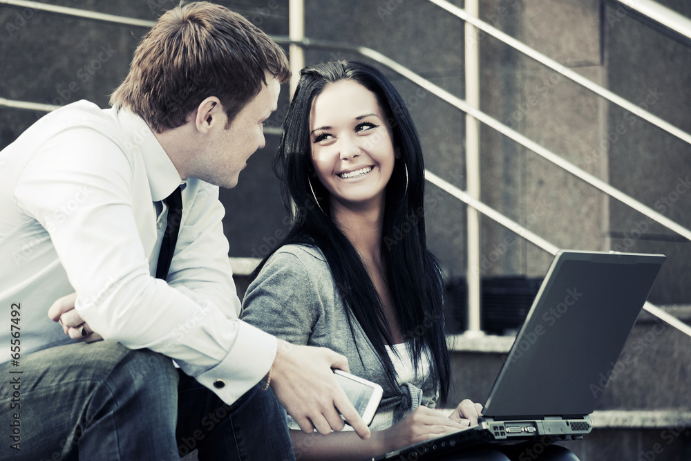 Young business couple using laptop outdoor Young business couple using laptop outdoor