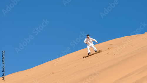 Man sandboarding in Namibia