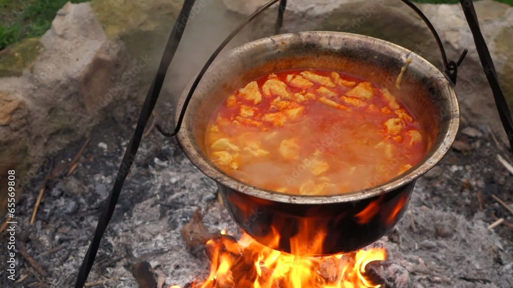 Hungarian paprika potatoes is cooking with noodles on a campfire Hungarian paprika potatoes is cooking with noodles on a campfire