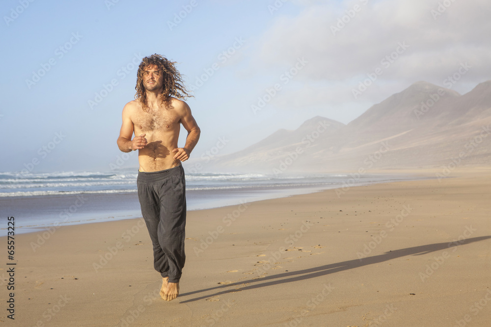 handsome young man running on the beach