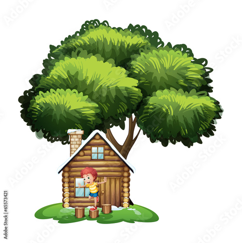A boy playing outside the small house under the tree