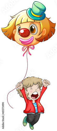 A happy young man holding a clown balloon