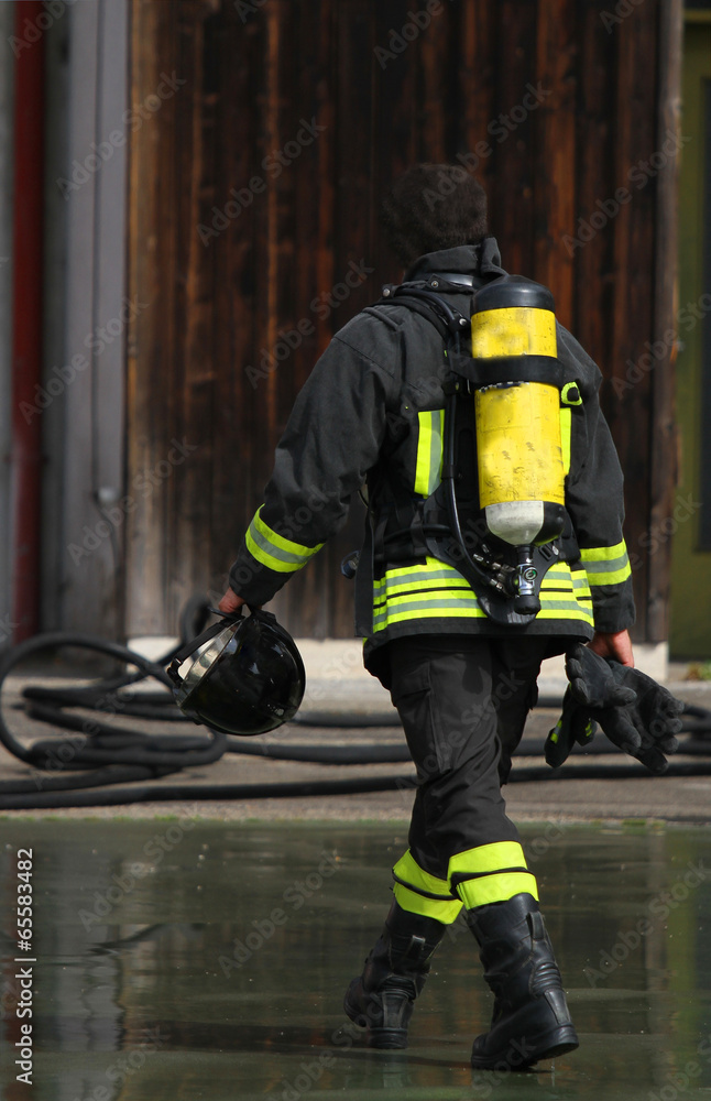 Fireman with the oxygen cylinder after turning off the fire Fireman with the oxygen cylinder after turning off the fire