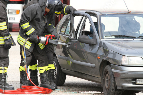firefighters with shears open the car doors after a serious car