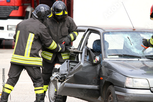 firefighters with pneumatic shears open the car doors