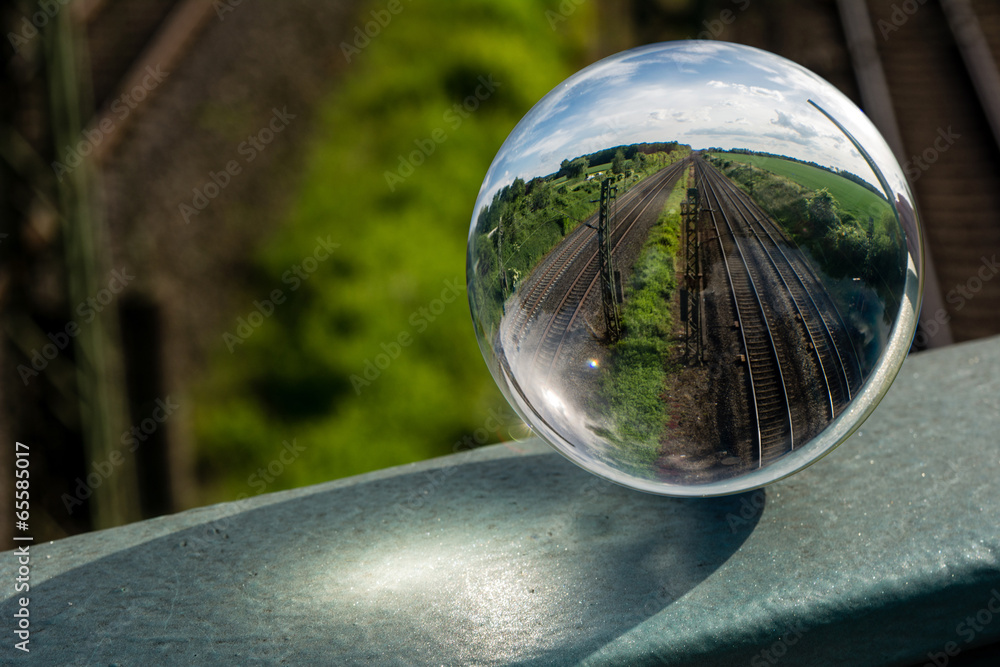 Fototapeta premium Glaskugel mit Bahnschienen