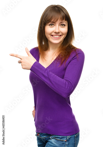 Portrait of a young woman pointing to the left