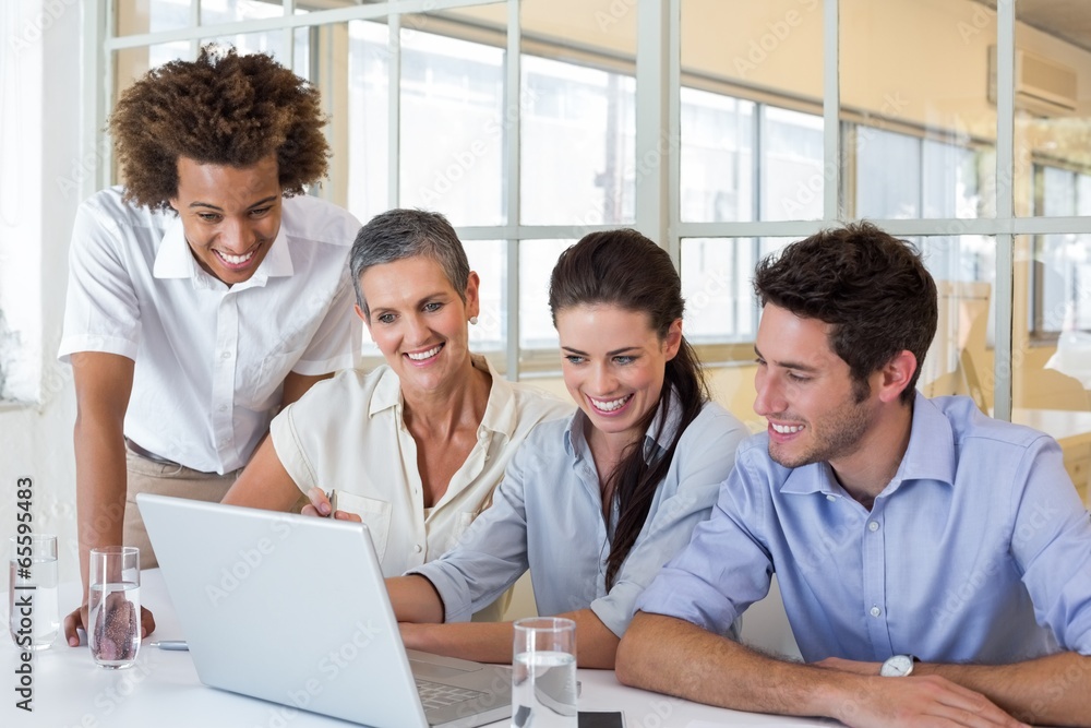 Group of business people looking at laptop Group of business people looking at laptop