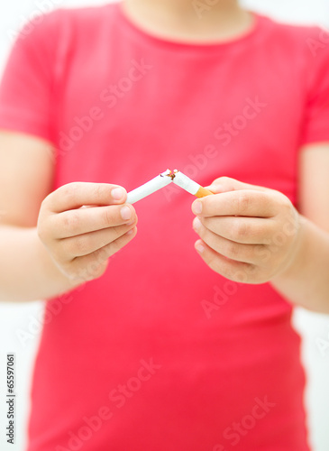 Young girl is breaking a cigarette