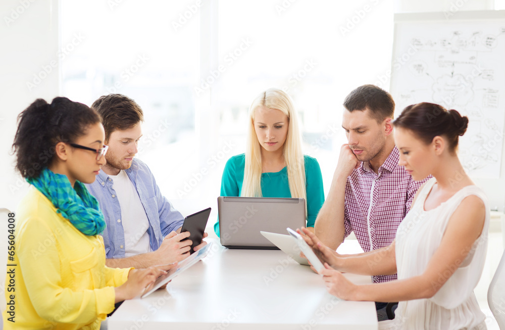 serious team with table pc and laptop in office serious team with table pc and laptop in office