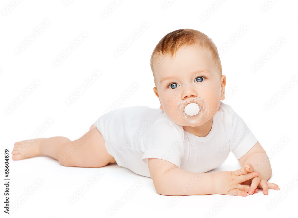 smiling baby lying on floor with dummy in mouth smiling baby lying on floor with dummy in mouth