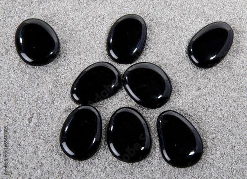 Canvas Print Composition of black pebbles on the sand