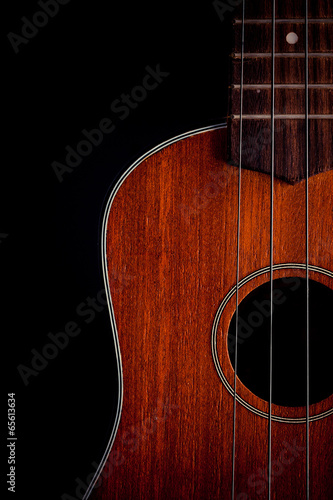 Ukulele hawaiian guitar over dark background.