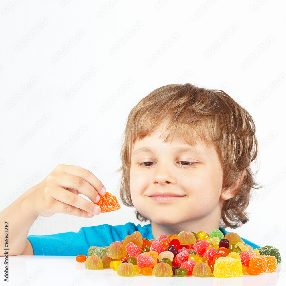 Smiling child with colored jelly candies on a white background Smiling child with colored jelly candies on a white background