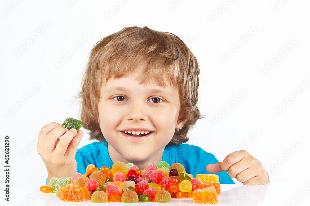 Smiling boy with candies on a white background Smiling boy with candies on a white background